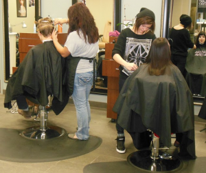 Madison and Co. stylists work on two clients in the Anderson Student Center. The salon opened on April 1, 2014, and will be closing on Dec. 19. (Theresa Bourke/TommieMedia)