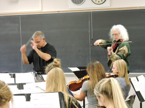 Director Matt George and electric viola player and composer Martha Mooke rehearse with the St. Thomas Orchestra Thursday. The university commissioned an original piece from Mooke, which the St. Thomas Wind Ensemble will premier Sunday. (Lauren Schaffran/TommieMedia)