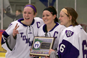 Seniors Tara Baago, Paige Baldwin and Dani Lobejko of the St. Thomas women's hockey team hold the conference title plaque. The women's hockey team was one of six winter sports teams that won the MIAC championship. (Andrew Brinkmann/TommieMedia)