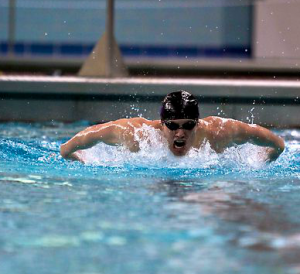 Freshman Bailey Biwer surfaces for a breathe during a race. Biwer was part of a MIAC champion men's swimming and diving team. (Madeleine Davidson/TommieMedia)