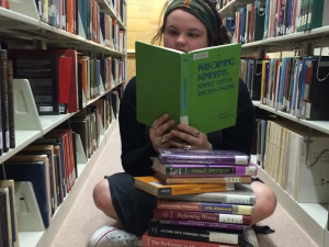 Junior Melanie Kraemer reads a book on feminism as part of preparation for her  project with the Young Scholars Research Grant. Kraemer will spend 10 weeks this summer researching, reading, and writing about eco-feminism in Victorian era Britain. (Jeffrey Langan/TommieMedia)