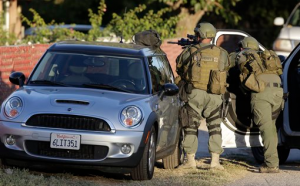 Law enforcement search for a suspect in a mass shooting that occurred at a Southern California social services center on Wednesday, Dec. 2, 2015, in San Bernardino, Calif. One or more gunmen opened fire Wednesday at a California center that serves people with developmental disabilities, shooting several people as others locked themselves in their offices, desperately waiting to be rescued by police, witnesses and authorities said. (AP Photo/Chris Carlson)