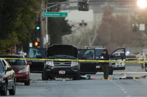 An investigator looks at a Black SUV that was involved in a police shootout with suspects, Thursday, Dec. 3, 2015, in San Bernardino, Calif. A heavily armed man and woman opened fire Wednesday on a holiday banquet, killing multiple people and seriously wounding others in a precision assault, authorities said. Hours later, they died in a shootout with police. (AP Photo/Jae C. Hong)