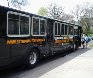 One of the new St. Thomas buses picks up students to bring to the Minneapolis campus. (Sean Crotty/TommieMedia)