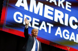 Republican presidential candidate, businessman Donald Trump waves has he arrives for a campaign rally Monday in Manchester, N.H. (AP Photo/David Goldman)