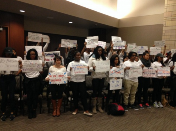 Students display signs at an Undergraduate Student Government meeting last November to protest club funding and other issues. The group, which became Students of Color: Claim Our Seats recommended that St. Thomas create a space to foster inclusion. (Grace Pastoor/TommieMedia) 