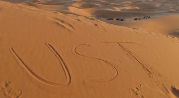 Students studying abroad in Morocco show their school pride by writing "UST" in the sand. More women than men are studying abroad according to data from the Institute of International Education. (Simeon Lancaster/TommieMedia)