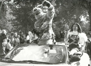 TommieFloat Cheerleader Sousada Chidthachack rides in the Grand Marshall car with Tommie the Tomcat in the 2002 Homecoming parade. (JOY LOMURRAY/THE AQUIN)