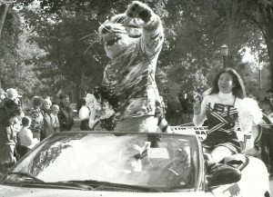 Cheerleader Sousada Chidthachack rides in the Grand Marshall car with Tommie the Tomcat in the 2002 Homecoming parade. (JOY LOMURRAY/THE AQUIN)