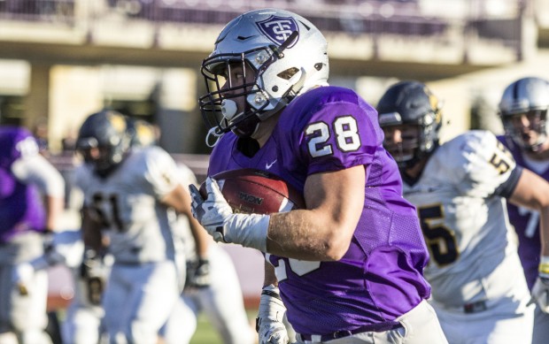 Freshman running back Tucker Trettel evades defenders against Carleton on Nov. 7. Trettel ran for 110 yards in the game and is currently the number two rusher on the St. Thomas football team. (Andrew Brinkmann/TommieMedia) 