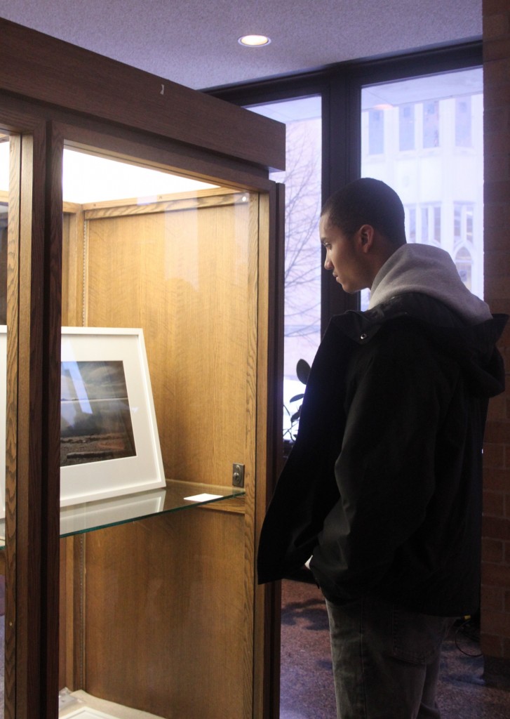 Freshman Timothy Johnstead admires the photographs in the exhibit. (Gina Dolski/TommieMedia)