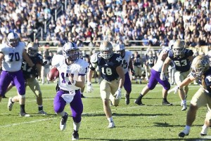 Quarterback John Gould looks upfield as he runs from Bethel defenders. St. Thomas will face Betel again Saturday. (Madeleine Davidson/TommieMedia)