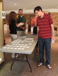 Freshman John Mores grabs his name tag before entering the first Connect meeting. (Ariel Kendall/TommieMedia)