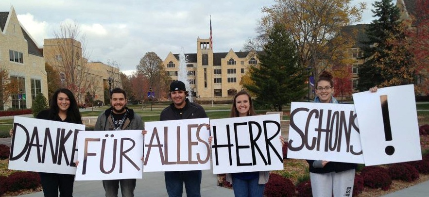 <p>Seniors Emily Leininger, Bobby Ranallo, Megan Rhein and Katie Monnin and junior Joe Ceplecha display signs in German thanking professor Paul Schons. Schons, a long-time St. Thomas German professor died Sunday. (Photo courtesy of Megan Rhein)</p> 