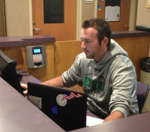 Junior Danny Glass mans the Flynn Residence Hall desk Tuesday night. Glass is not a resident adviser, but a student worker who works at the desk while the RA on-duty makes their nightly rounds to check on their residents. (Baihly Warfield/TommieMedia) 