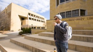 Dustin Hassett smokes a cigarette outside the O'Shaughnessy-Frey Library. (John Kruger/TommieMedia)