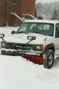 A plow clears a South Campus parking lot Monday while snow continues to fall. (Gina Dolski/TommieMedia)