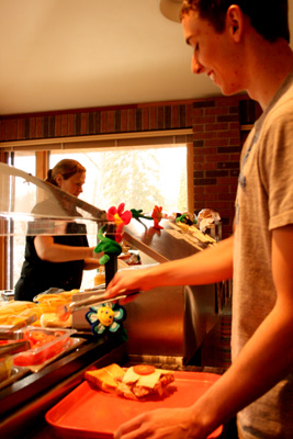 <p>Freshman David Artl puts some smaller Roma tomatoes on his sandwich in the Binz cafeteria Thursday. (Shane Kitzman/TommieMedia)</p>