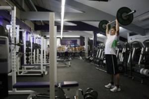 <p>Sophomore Kelvin Kosbab finishes a lift in the temporary weight room facility located under the bleachers of O'Shaughnessy Stadium. (Michael Ewen/TommieMedia)</p>